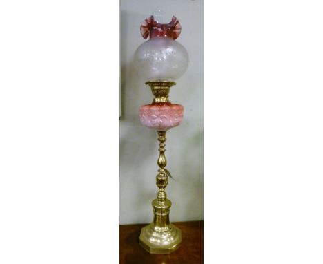 Late 19th/early 20th Century oil lamp having opaque pink relief moulded reservoir on a slender brass column and octagonal foo