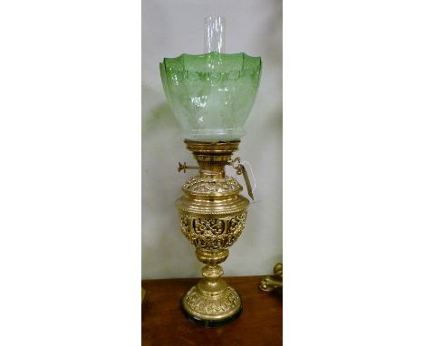 Late 19th/early 20th Century oil lamp, the brass reservoir held within a pierced cast brass cup shaped stand with domed foot 