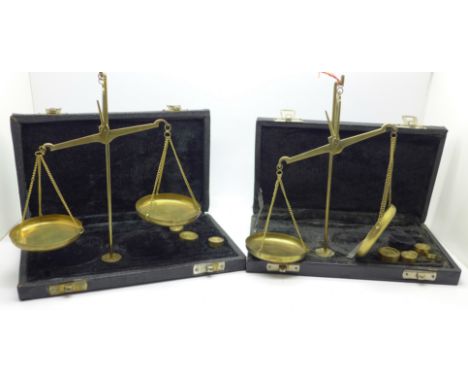 Two sets of brass merchants scales, cased, lacking some weights