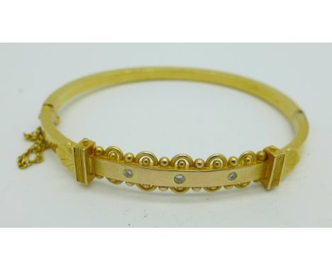 A 15ct gold and three stone diamond bangle, 8.6g, fastener a/f