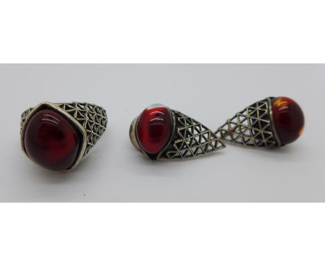 A white metal and red stone ring and a pair of matching earrings, T