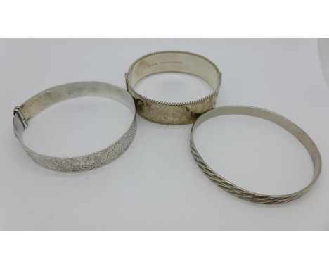 Two hallmarked silver bangles and one other bangle