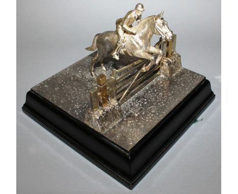 A TWO-COLOUR SILVER EQUESTRIAN GROUP, horse and rider jumping a five bar gate 7.5ins square. London 1963 Maker: B.S.