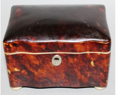 A SMALL REGENCY TORTOISESHELL SHAPED TEA CADDY with ivory banding, lift up lid, supported on ball feet 4.5ins wide.