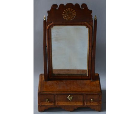 AN 18TH CENTURY WALNUT TOILET MIRROR with fretwork top and shelf, the base with three drawers and supported on bracket feet.