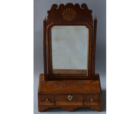 AN 18TH CENTURY WALNUT TOILET MIRROR with fretwork top and shelf, the base with three drawers and supported on bracket feet.