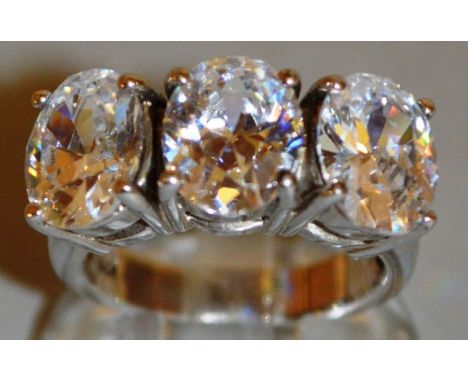 A LARGE THREE STONE BRILLIANT SET HALF HOOP RING.