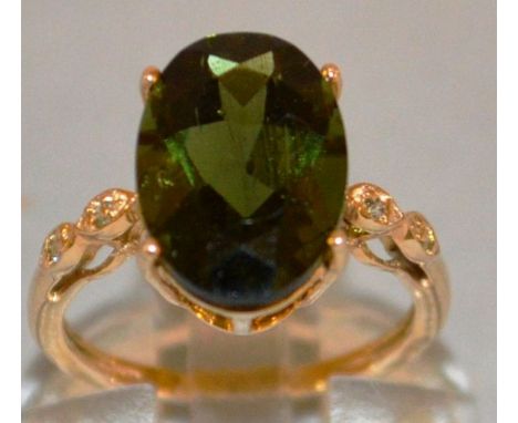 A LARGE GREEN STONE DRESS RING set in 9ct gold.