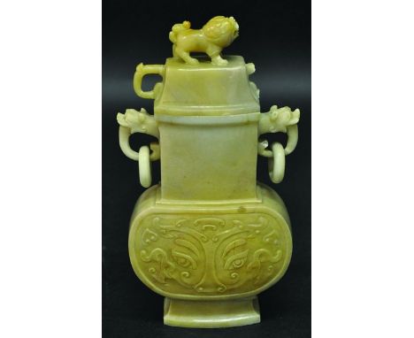 A CHINESE JADE-LIKE VASE OF ARCHAIC FORM, with double ring handles, the sides decorated with taotie masks, the stone of an un