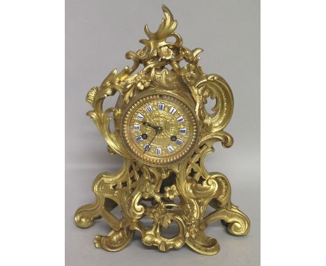 AN ORMOLU 19TH CENTURY ROCOCO MANTLE CLOCK by STIFFIELD AND CARTIER, PARIS. 12ins high.