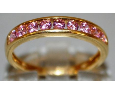 A GOOD NINE PINK STONE HALF ETERNITY RING set in 9ct gold.