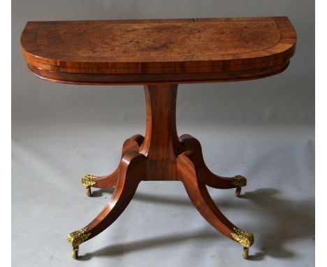 A GOOD REGENCY BURR ELM ROSEWOOD CROSSBANDED CARD TABLE with folding top and green baize interior, centre column on a quadrup