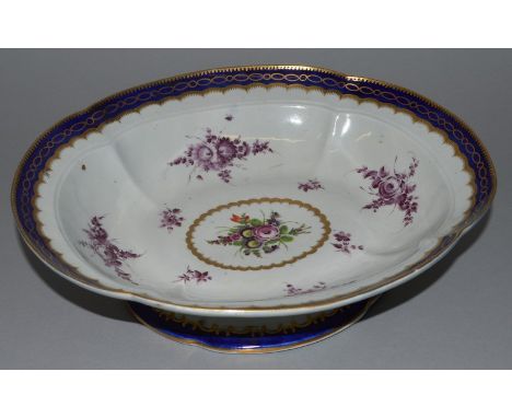 AN 18TH CENTURY WORCESTER PEDESTAL DISH painted with colourful flowers in a feather edged gilt oval surrounded by floral spra