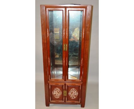 A CHINESE REDWOOD AND MOTHER-OF-PEARL INLAID STANDING CARVED CUPBOARD with mirrored interior over a small pair of panel doors