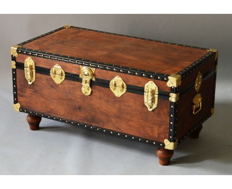 A BRASS BOUND TRUNK converted into a coffee table on turned legs. 2ft wide.