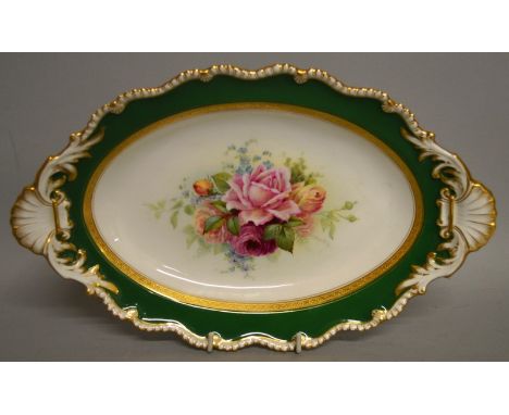 A ROYAL WORCESTER OVAL DISH painted with roses inside an acid etched inner border and gadroon rim by Ernest Barker, signed, d