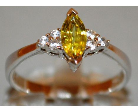 A YELLOW STONE AND DIAMOND RING set in 9ct gold.
