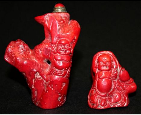 TWO CHINESE RED CORAL SNUFF BOTTLES & STOPPERS, each carved in the form of Budai and a tree trunk, 3in & 1.6in high. (2)