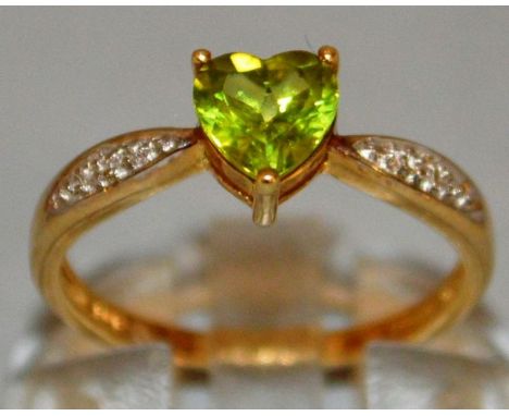 A GREEN TEARDROP STONE RING with diamond shoulders, set in 9ct gold.
