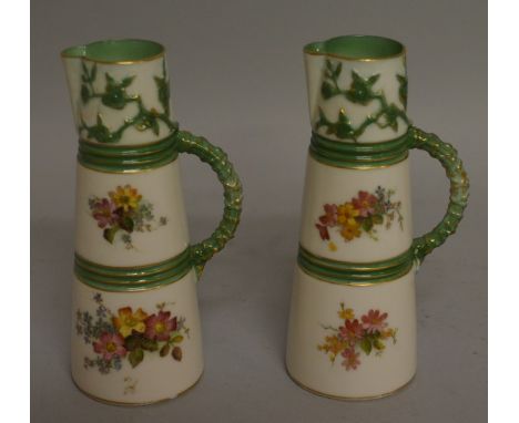 A ROYAL WORCESTER PAIR OF CLARET JUGS of unusually small size, painted with flowers, the jug with green highlights c.1903.