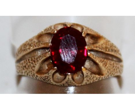A GOLD RED STONE RING.