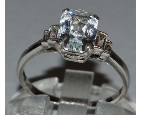 A GOOD WHITE SAPPHIRE AND DIAMOND RING set in platinum, baguette cut central white sapphire with diamond shoulders. Sold with