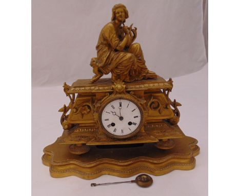 A late 19th century French spelter mantle clock, circular white enamel dial with Roman numerals surmounted by a classical fig
