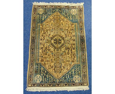 Persian wool carpet light brown ground with repeating motif decoration within a turquoise and brown  border with repeating ge