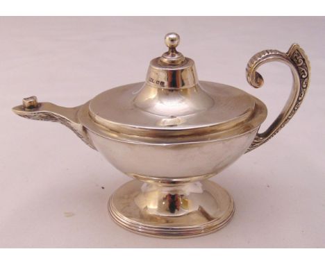 A Victorian hallmarked silver cigar lighter in the form of Aladdin's lamp with flying scroll handle, domed pull off cover on 