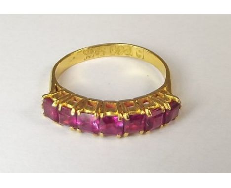 RUBY RING.
A 22ct. gold (Middle Eastern stamped, tested), half hoop ring, set with seven square cut rubies. 