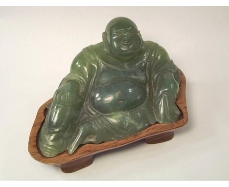 JADE BUDDHA.
A carved green jade Buddha on hardwood stand. Length 10.5cm.