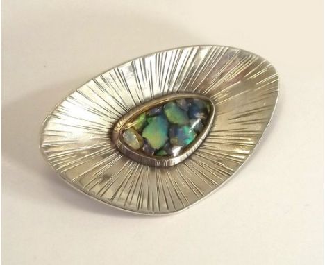 MODERNIST BROOCH.
A hand made silver modernist brooch, set with encapsulated boulder opal centre. Signed R. Riederer & dated 