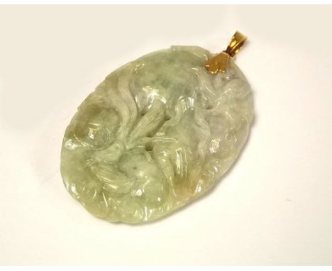 JADE PENDANT.
A 14ct. gold mounted, Chinese pale green carved jade pendant. 5 x 3.5cm.