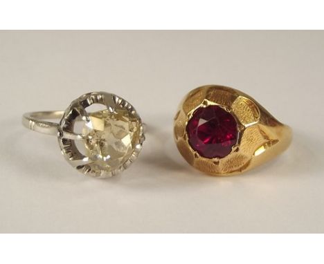 DRESS RINGS.
A yellow metal dress ring, set a synthetic ruby & one other white metal dress ring, set an irregularly cut white