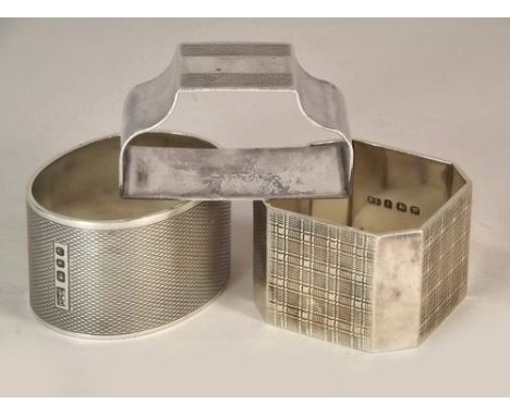 NAPKIN RINGS.
A heavy Mappin & Webb engine turned silver oval napkin ring, a tartan engraved napkin ring & one other.