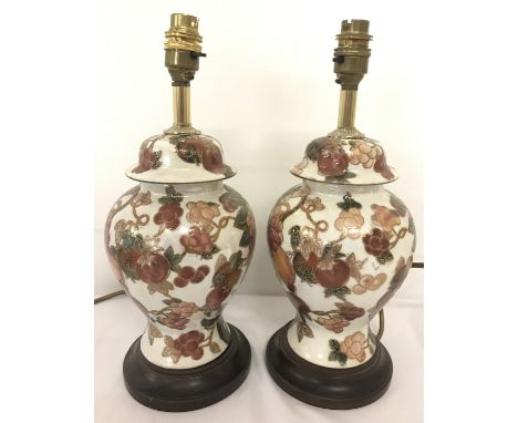 A pair of ceramic table lamps with floral and gilt decoration.  Approx. 34cm tall.