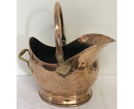 A vintage copper coal scuttle with hinged handle.  Approx. 30cm diameter.