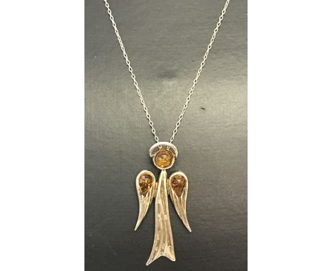 A silver and amber set pendant in the shape of an angel, on an 18" fine curb chain.  