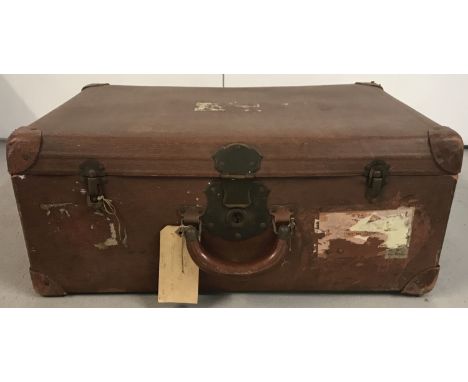 A large vintage suitcase with brass clasps and remnants of a G.W.R baggage label.  Approx. 26cm x 64cm 45cm.