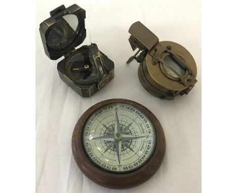 2 brass cased compasses together with a wooden dome topped desk compass. Square shaped brass compass marked "Kelvin &amp; Hug