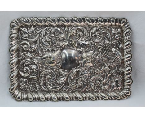 An Edwardian silver dressing table tray of rectangular form having embossed mask, scroll and bird decoration with raised rim,