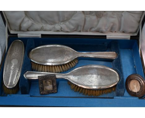 A cased part set of silver dressing table brushes having having engine turned moon shine decoration, Birmingham 1924/25 Samue