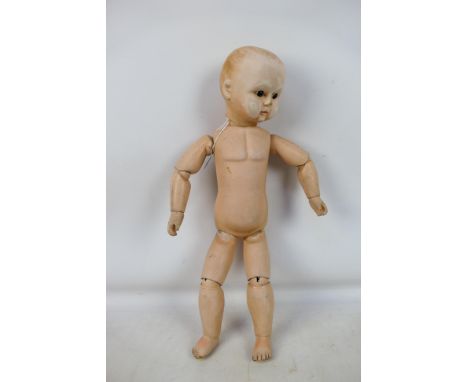 Unmarked Maker - An unboxed and unmarked composition doll which measures approximately 54cms in height with open glass eyes, 