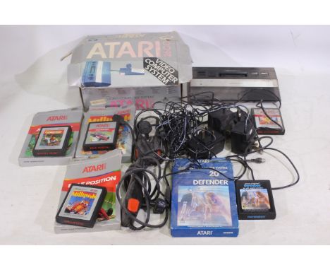 Atari - A boxed Atari 2600 video games console with a small selection of games (some boxed) including Defender and Pac-Man. T