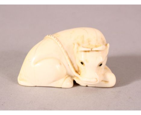 A JAPANESE MEIJI PERIOD CARVED IVORY NETSUKE OF A RECUMBENT OXEN - the oxen recumbent - the underside signed " Tamaishi" 5cm