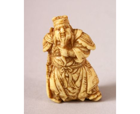 A JAPANESE MEIJI PERIOD CARVED IVORY NETSUKE OF A WARRIOR - the warrior stood in traditional attire holding his beard - the u