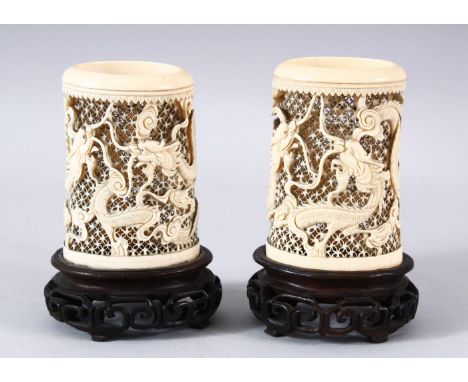 A PAIR OF 19TH CENTURY CHINESE CANTON CARVED IVORY OPENWORK VASES - each vase carved to depict dragons chasing the pearl asid