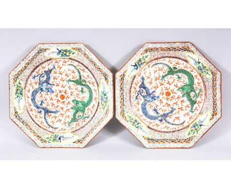 A PAIR OF CHINESE FAMILLE ROSE OCTAGONAL PORCELAIN PLATES - each decorated with twin dragons chasinig the pearl amongst cloud