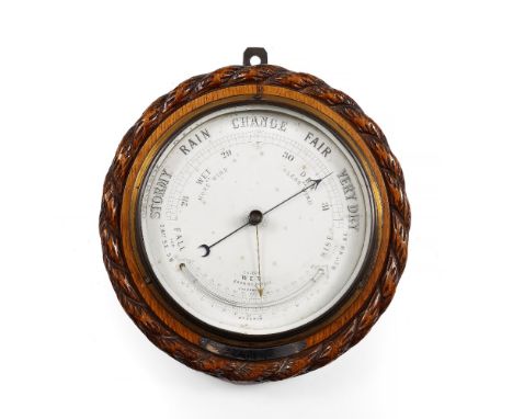 A VICTORIAN ANEROID BAROMETER AND THERMOMETER in a circular rope carved oak case with presentation plaque, 26.5cm diameter