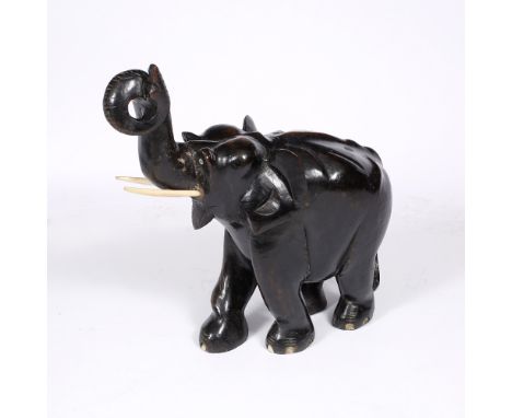 A LARGE INDIAN CARVED WOOD AND EBONISED MODEL of an elephant with upraised trunk, approximately 55cm high x 53cm long